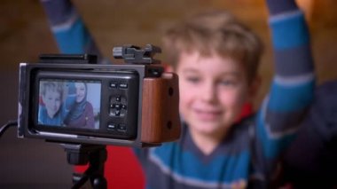 Vloggers olarak hijab kayıt video neşeli küçük çocuk ve müslüman annesi kamera objektifinde Shot.