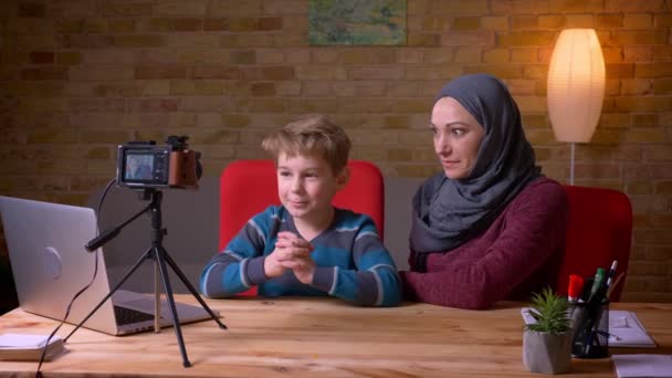 Joyful liten pojke och hans muslimska mor i hijab inspelning video som vloggers på kameran. — Stockvideo