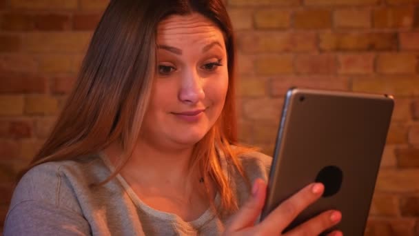 Close-up shot van overgewicht langharige vrouwelijke Freelancer werkt aandachtig met telefoon in gezellige huiselijke sfeer. — Stockvideo