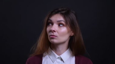 Siyah arka planda yorgun ve sıkılmış olan esneyen genç esmer iş kadını Portresi.