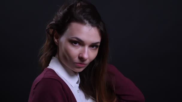 Retrato de joven mujer de negocios morena ajusta el pelo coqueteando con la cámara sobre fondo negro . — Vídeos de Stock