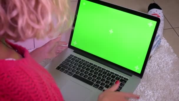 Κοντινό πλάνο πίσω βολή της νοικοκυράς σε ροζ πουλόβερ πληκτρολόγηση σε φορητό υπολογιστή με μεγάλη συγκέντρωση στην ατμόσφαιρα του σπιτιού. — Αρχείο Βίντεο