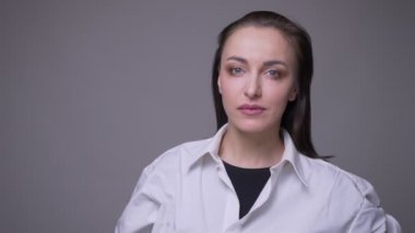 Beyaz gömlekli yetişkin çekici beyaz kadın closeup portre gri izole arka plan ile kamera bakıyor