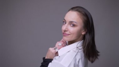 Yetişkin çekici beyaz kadın güvenle gülümseyen ve gri izole arka plan ile kamera bakarak göz kırpma yapmak Closeup portre