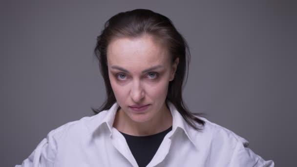 Closeup portrait of adult attractive caucasian female being angry and furious looking at camera with background isolated on gray — Stock Video