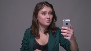 Yetişkin çekici esmer kadın o telefonda bir video görüşmesi olan Closeup ateş gri izole arka plan ile duygusal konuşma