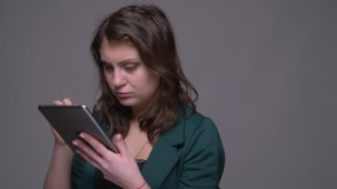 Tablette yetişkin çekici esmer kadın mesajlaşma closeup ateş ve gri izole arka plan ile kamera bakıyor