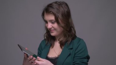 Tablet kullanarak yetişkin çekici esmer kadın Closeup ateş ve gri izole arka plan ile kameraya uygulama ile yeşil renk anahtar ekranı gösteren