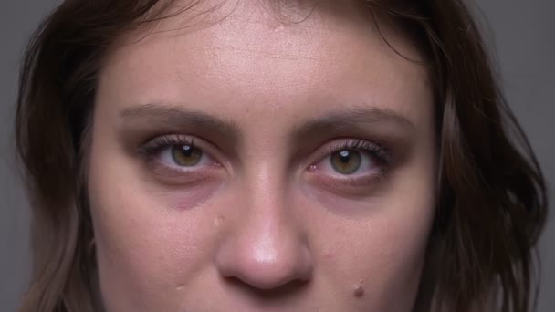 Gros plan shoot de adulte attrayant brunette visage féminin avec ses yeux étant fermé ouverture et regarder la caméra avec fond isolé sur gris — Video