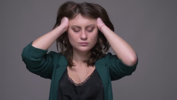 Closeup shoot af voksen attraktiv brunette kvindelig bliver trist og skuffet ser på kamera med baggrund isoleret på grå – Stock-video