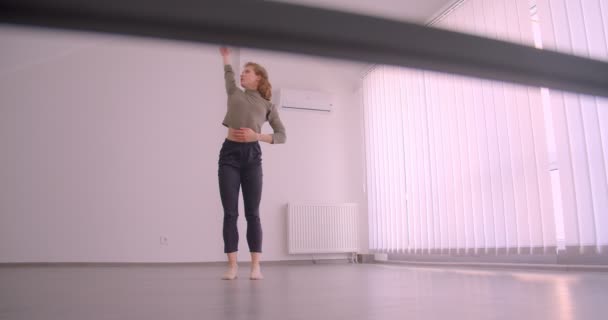 Τρυφερή καυκάσια χορεύτρια που τεντώνει και κάνει πρόβες στο ελαφρύ μάθημα μπαλέτου. — Αρχείο Βίντεο