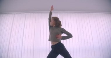 İhale kafkas profesyonel balerin aktif dans ve panjur arka plan üzerinde ışık stüdyosunda iplik.