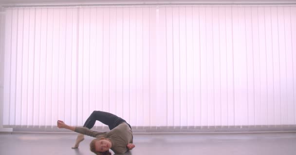 Tender kaukázusi szakmai balerina táncolnak elragadóan és spinning könnyű osztályban zsalu háttér. — Stock videók