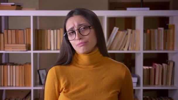 Ganska brunett lärare gester facepalm täcker ansikte med hand som irriterad och irriterad på biblioteket. — Stockvideo