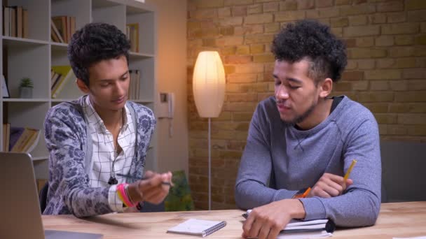 Närbild shoot av afroamerikanska och indiska manliga studenter lärande tillsammans. Två vänner som spelar en Tic Tac Toe och ha kul — Stockvideo