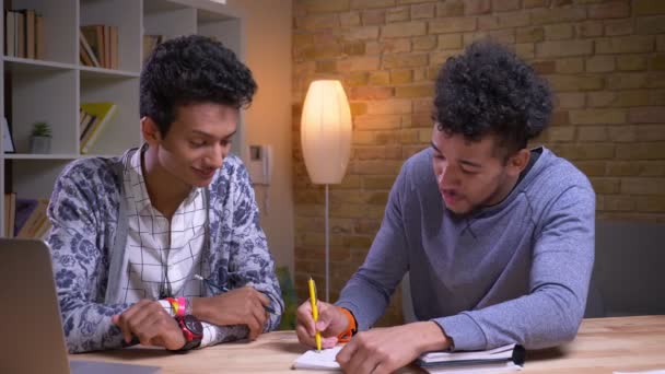 Närbild shoot av afroamerikanska och indiska manliga studenter lärande tillsammans. Två vänner som spelar en Tic Tac Toe och argumentera — Stockvideo