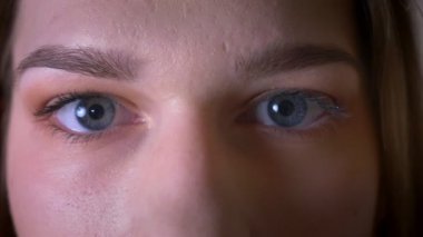 Gözleri kameraya bakarak ve yanıp sönen genç esmer kadın yüz Closeup ateş