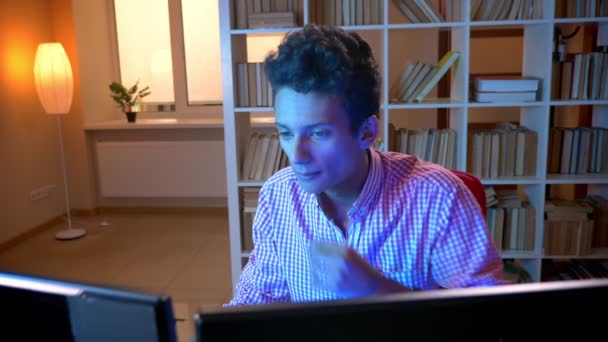 Zbliżenie strzelać młodego indyjskiego atrakcyjnego mężczyzny grając w gry wideo na komputerze w pomieszczeniu w przytulnym mieszkaniu z neonowym światłem — Wideo stockowe