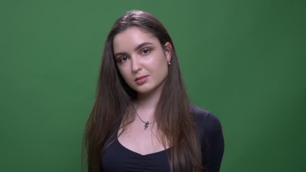 Closeup portrét mladé, hezké, bruneté ženské, která se dívá na kameru s pozadím izolovaným na zeleném — Stock video