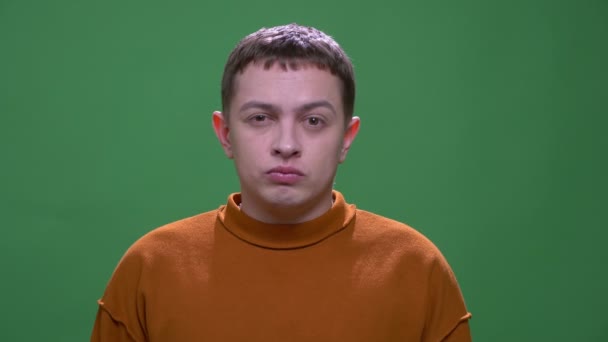 Nahaufnahme eines jungen attraktiven kaukasischen Mannes, der wütend und frustriert in die Kamera schaut, mit einem auf Grün isolierten Hintergrund — Stockvideo