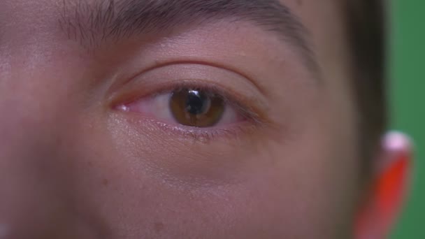 Gros plan demi-visage pousse de jeune homme caucasien attrayant avec les yeux regardant caméra — Video