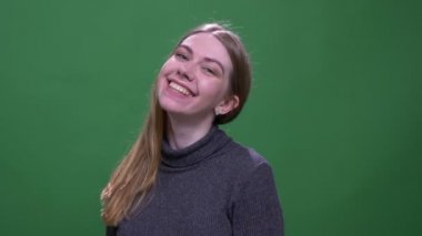 Pretty sarışın model yeşil renk arka plan izole kamera içine mutlu bir şekilde gülümseyen.