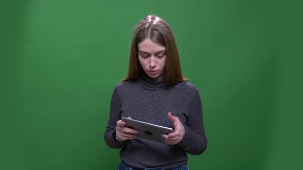 Joven mujer de negocios rubia trabajando con atención con la tableta aislada sobre fondo cromakey verde . — Vídeo de stock