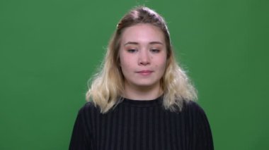 Yeşil izole arka plan ile kamera bakarak genç güzel sarışın kafkas kadın Closeup portre