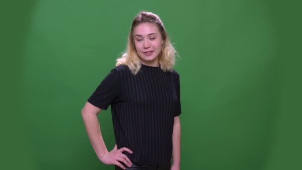 Close-up retrato de jovem bonita loira caucasiano fêmea posando na frente da câmera com fundo isolado no verde — Vídeo de Stock