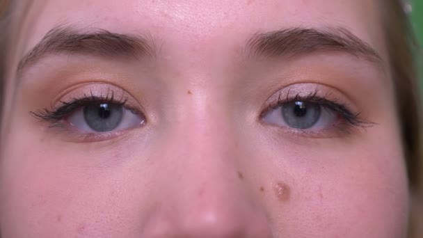 Close-up tiro de jovem rosto feminino caucasiano atraente com olhos olhando para a câmera — Vídeo de Stock
