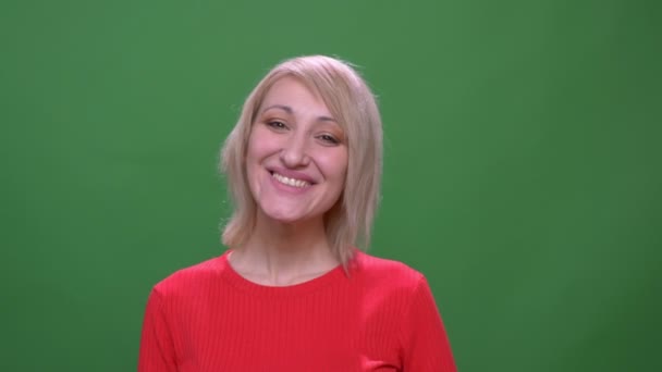 Medelålders blond korthårig modell ler vackert i kameran isolerad på grön Chromakey bakgrund. — Stockvideo