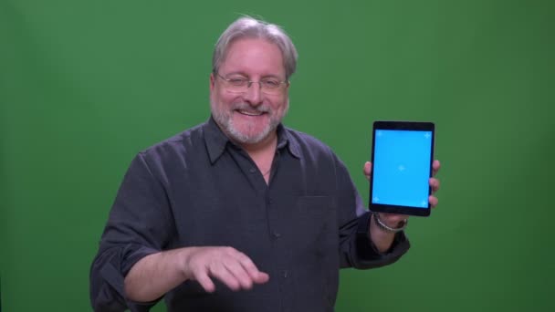 Homme d'affaires chevelu gris senior pointe doigt sur l'écran bleu de la tablette avec application isolée sur fond vert chromatique . — Video