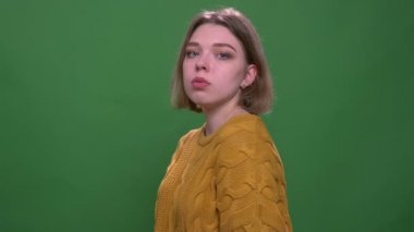 Yeşil izole arka plan ile kamera bakarak rahat olmak genç çekici kısa saçlı kadın dans Closeup ateş