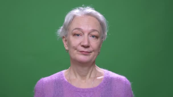 灰色の髪の祖母は、緑のクロマキーの背景に孤立して反対に迷惑な頭を振る. — ストック動画