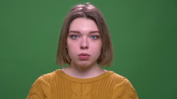 緑に隔離された背景を持つカメラを見て若い魅力的な短い髪の女性のクローズアップ撮影 — ストック動画