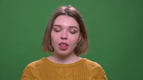 緑に隔離された背景を持つカメラを見て舌を見せる若い魅力的な短い髪の女性のクローズアップ撮影 — ストック動画