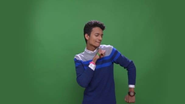 Primer plano de joven atractivo macho indio bailando con alegría mirando a la cámara con fondo aislado en verde — Vídeos de Stock