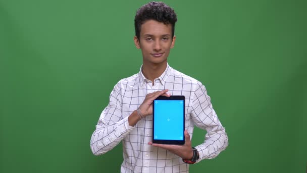 Close-up shoot van jonge aantrekkelijke Indiase man met behulp van de Tablet en het tonen van blauw scherm naar camera met achtergrond geïsoleerd op groen — Stockvideo