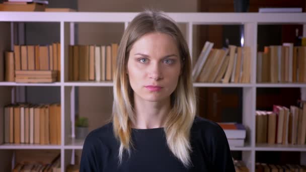 Nahaufnahme einer jungen attraktiven Studentin vor laufender Kamera in der Universitätsbibliothek — Stockvideo