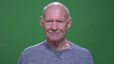 Yeşil izole arka plan ile kamera bakarak mutlu gülümseyen eski üst düzey kafkas adamın Closeup ateş