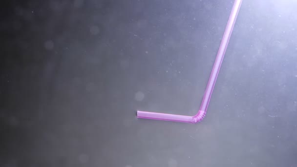 Close-up schieten van vissen zwemmen in een modderig water met een plastic stro drijvend in de Oceaan. Het probleem van de verontreiniging van de zee — Stockvideo