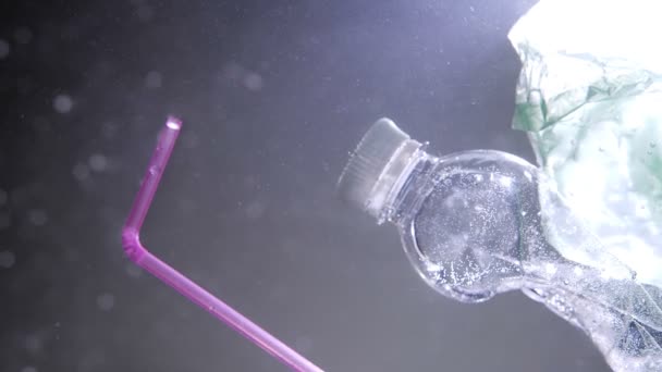 塑料瓶吸管和漂浮在海洋中的垃圾的特写镜头。全球海洋污染问题 — 图库视频影像