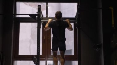 Spor salonunda kapalı barlar kendini kaldırarak yetişkin kas atletik vücut geliştirmeci Closeup geri görünümü ateş