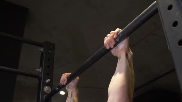 Крупним планом зйомки дорослого м'язового спортсмена, який піднімається на барах в приміщенні спортзалу — стокове відео