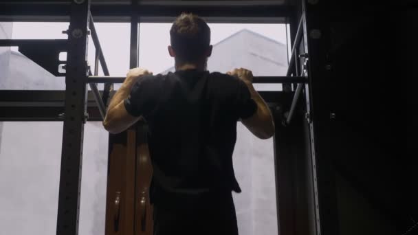 Primer plano vista trasera disparar de adulto muscular atlético hombre levantándose en las barras en el interior en el gimnasio — Vídeos de Stock