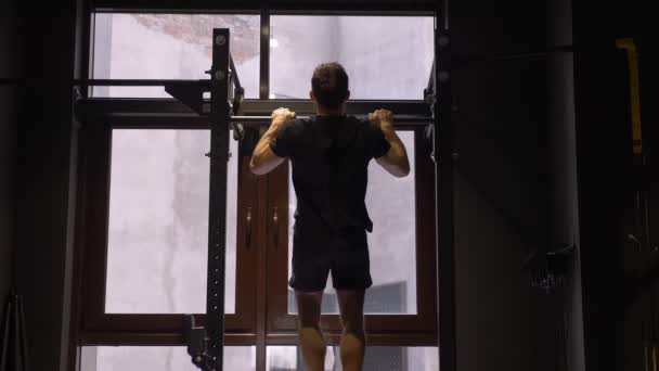 Closeup pohled zpět obraz dospělého svalnatého atletického kulturista, který se zvedá na mřížemi uvnitř tělocvičny — Stock video