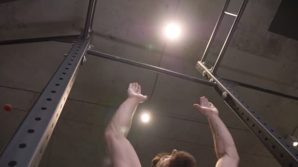 Närbild bottom up skott av vuxna muskulös atletisk man lyfta sig själv på barerna inomhus i gymmet — Stockvideo