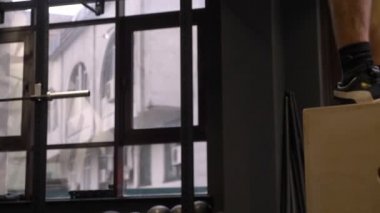 Yetişkin kas atletik adam eğitim Hiit kutunun üzerinde atlama ve spor salonunda kapalı kadar iterek Closeup ateş
