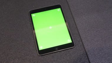 Spor salonunda yerde yatan izleme çalışması için uygulama ile yeşil ekran ile tablet closeup çekim