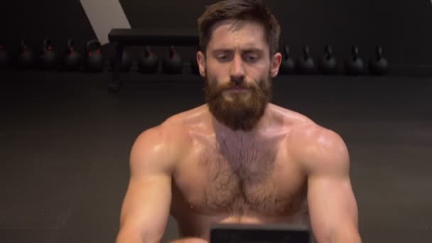 Närbild raka shoot av Adult Athletic bar överkropp man använda roddmaskin och göra styrketräning inomhus i gymmet — Stockvideo